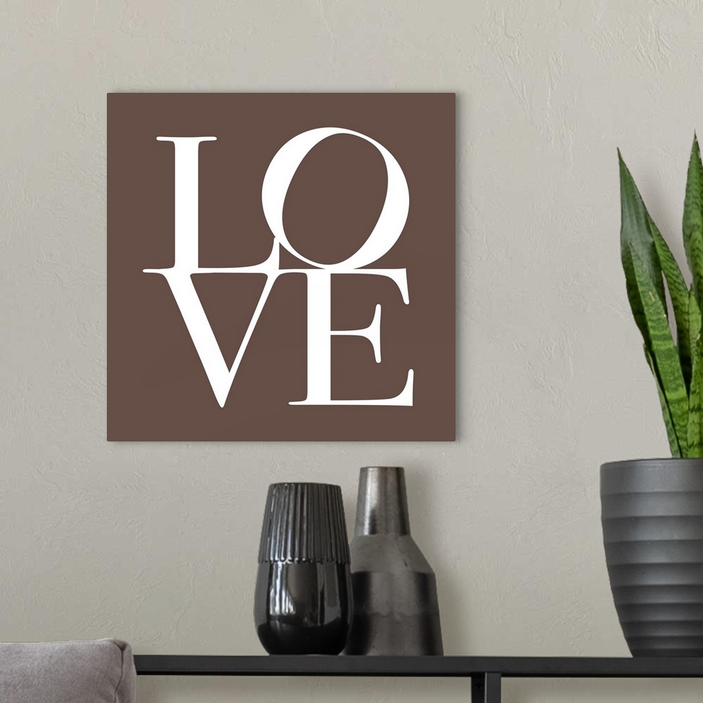 A modern room featuring The word LOVE is written in large white text against a taupe background.