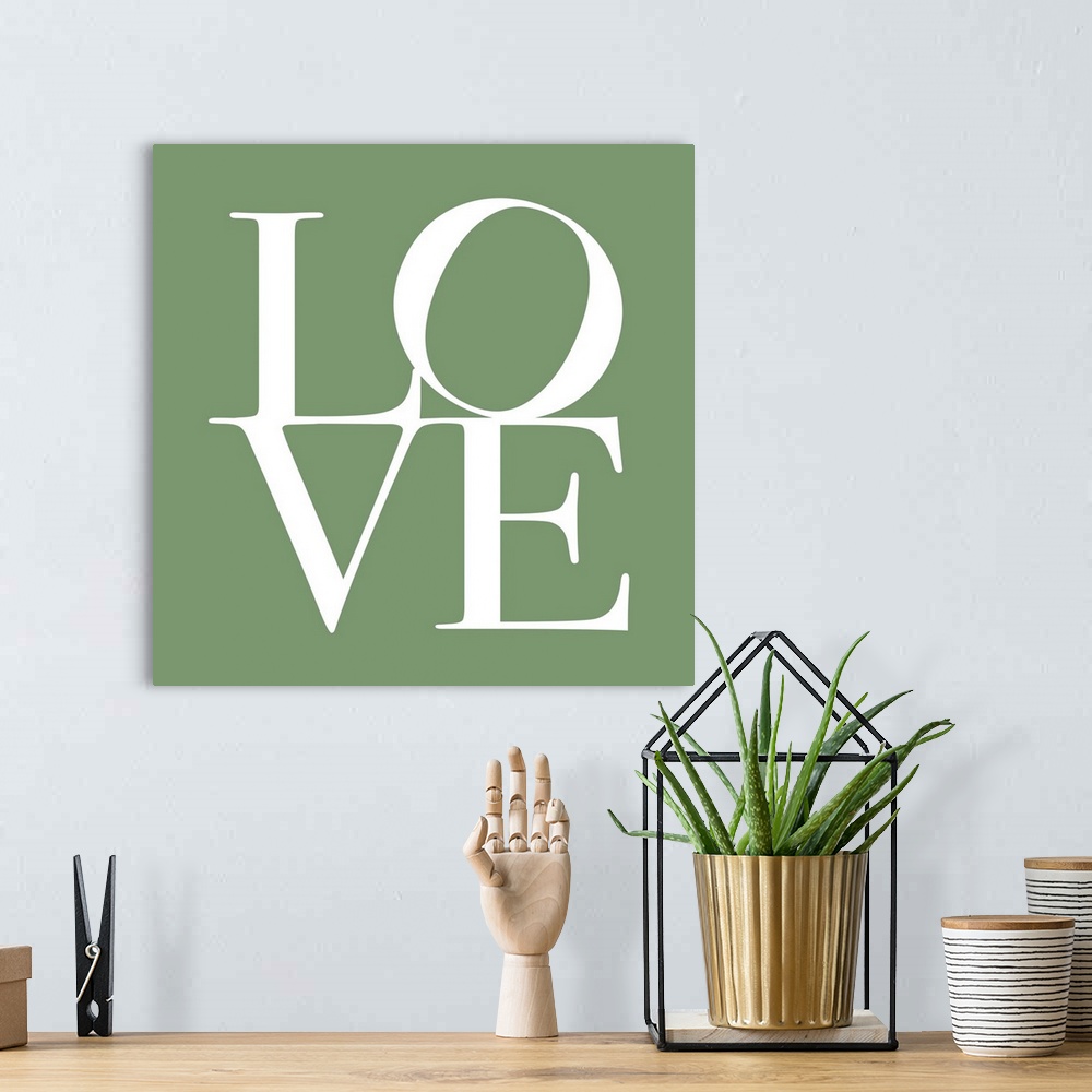 A bohemian room featuring LOVE, typography text art print and canvas print, with the word LOVE written against a green back...