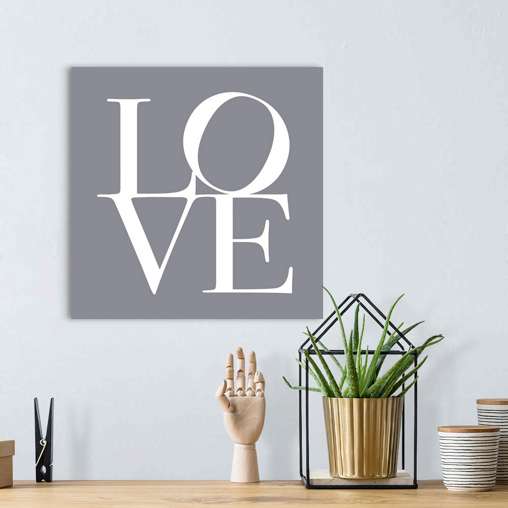 A bohemian room featuring LOVE, typography text art print and canvas print, with the word LOVE written against a gey backgr...