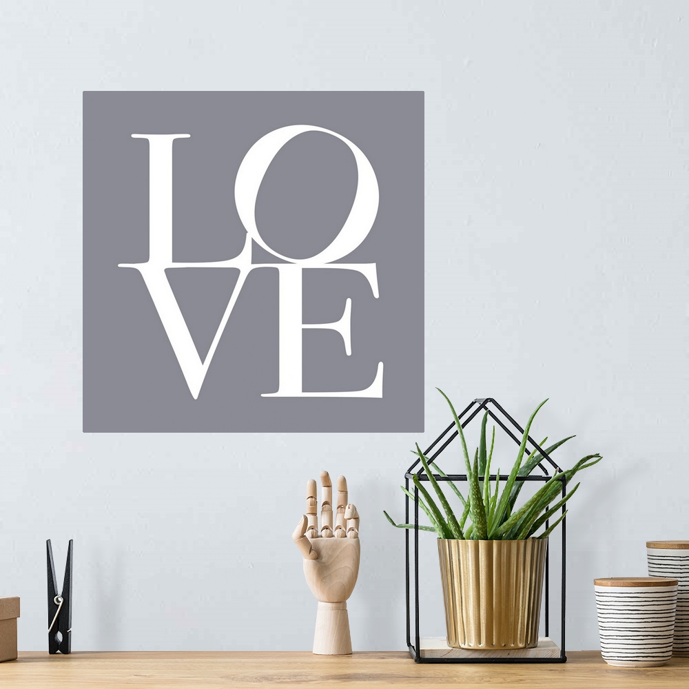A bohemian room featuring LOVE, typography text art print and canvas print, with the word LOVE written against a gey backgr...