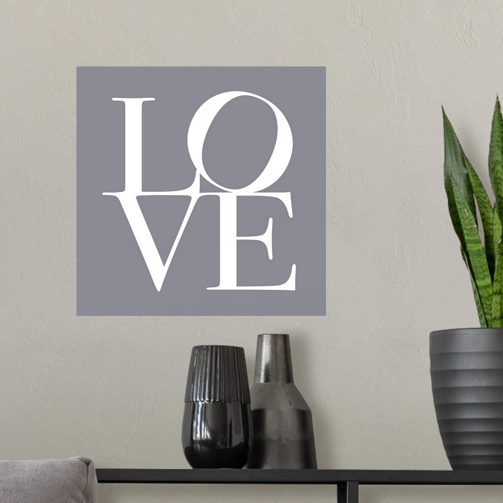 A modern room featuring LOVE, typography text art print and canvas print, with the word LOVE written against a gey backgr...
