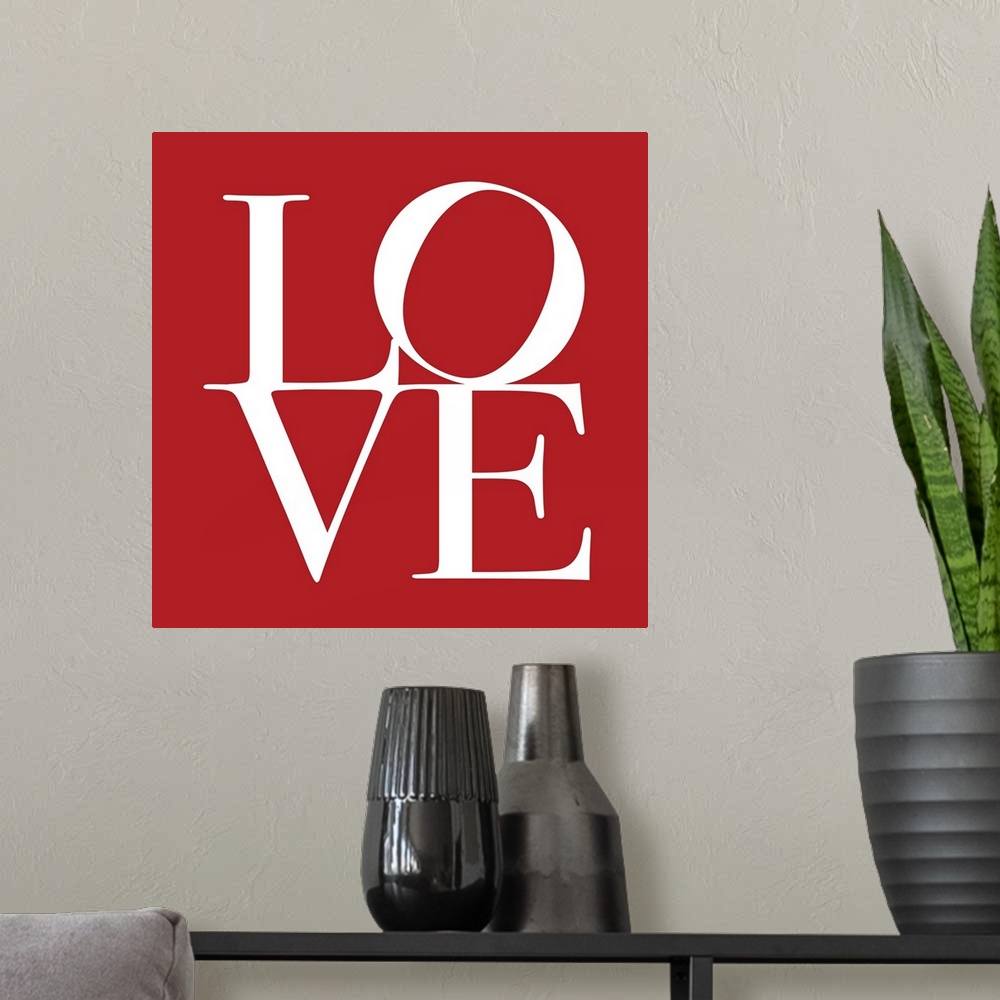 A modern room featuring Square art on a large canvas of the word "LOVE" with a tilted "O",  written against a solid red b...