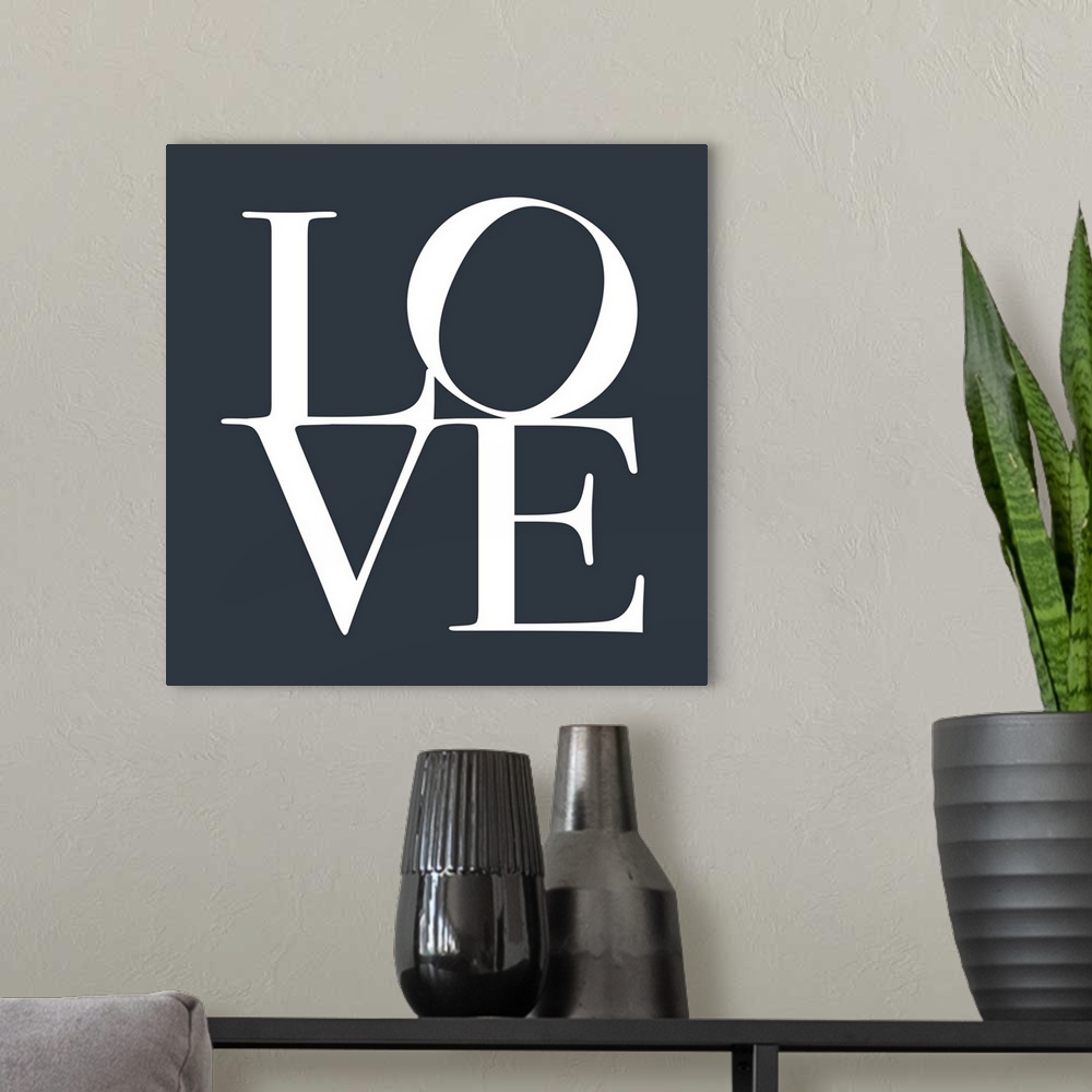 A modern room featuring LOVE, typography text art print and canvas print, with the word LOVE written against a slate grey...