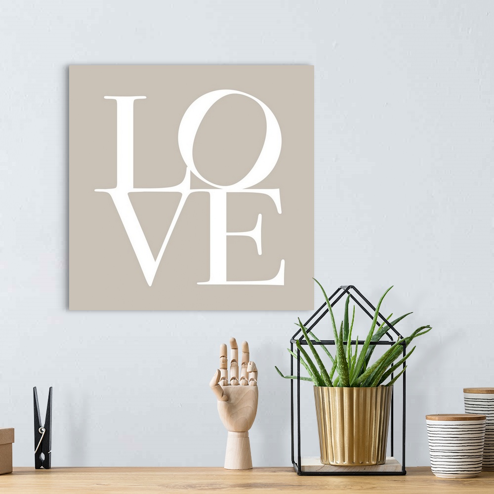 A bohemian room featuring LOVE, typography text art print and canvas print, with the word LOVE written against a taupe / be...