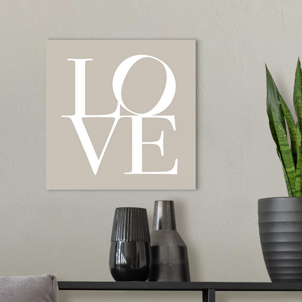 A modern room featuring LOVE, typography text art print and canvas print, with the word LOVE written against a taupe / be...