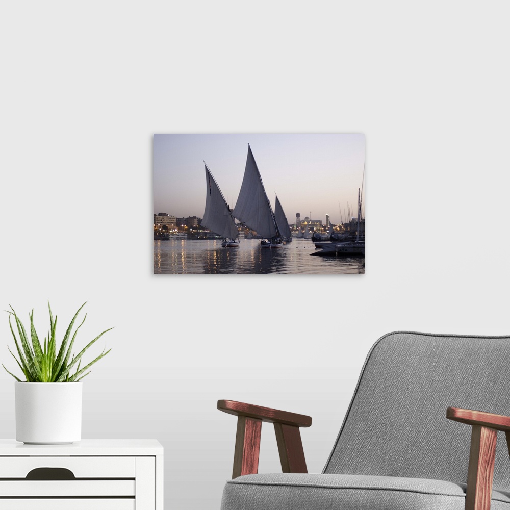A modern room featuring Aswan, skyline of the city in the background and 3 feluccas with big quadrangular sails
