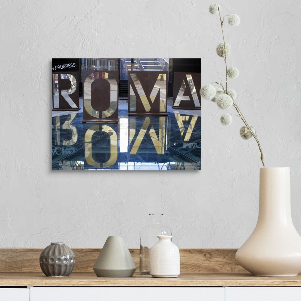 A farmhouse room featuring An interior photograph of letters, that are the Italian spelling of Rome, cut into steel that are...
