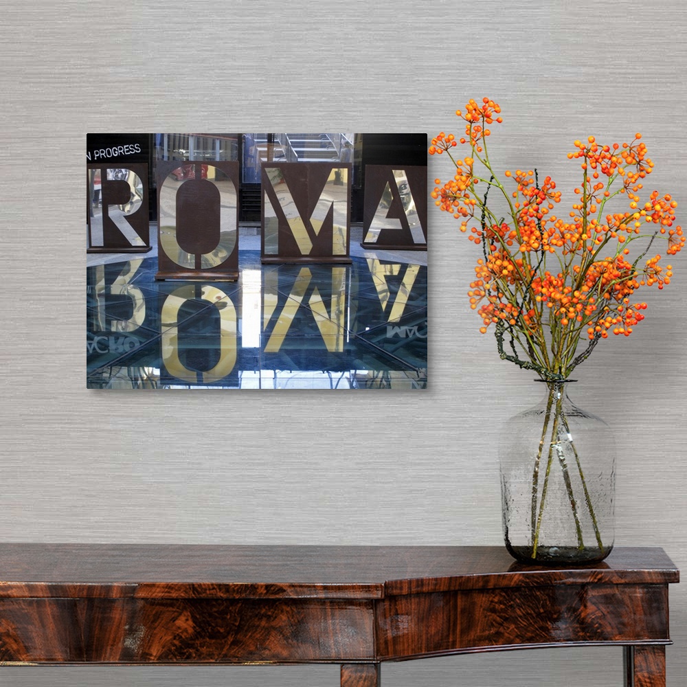 A traditional room featuring An interior photograph of letters, that are the Italian spelling of Rome, cut into steel that are...