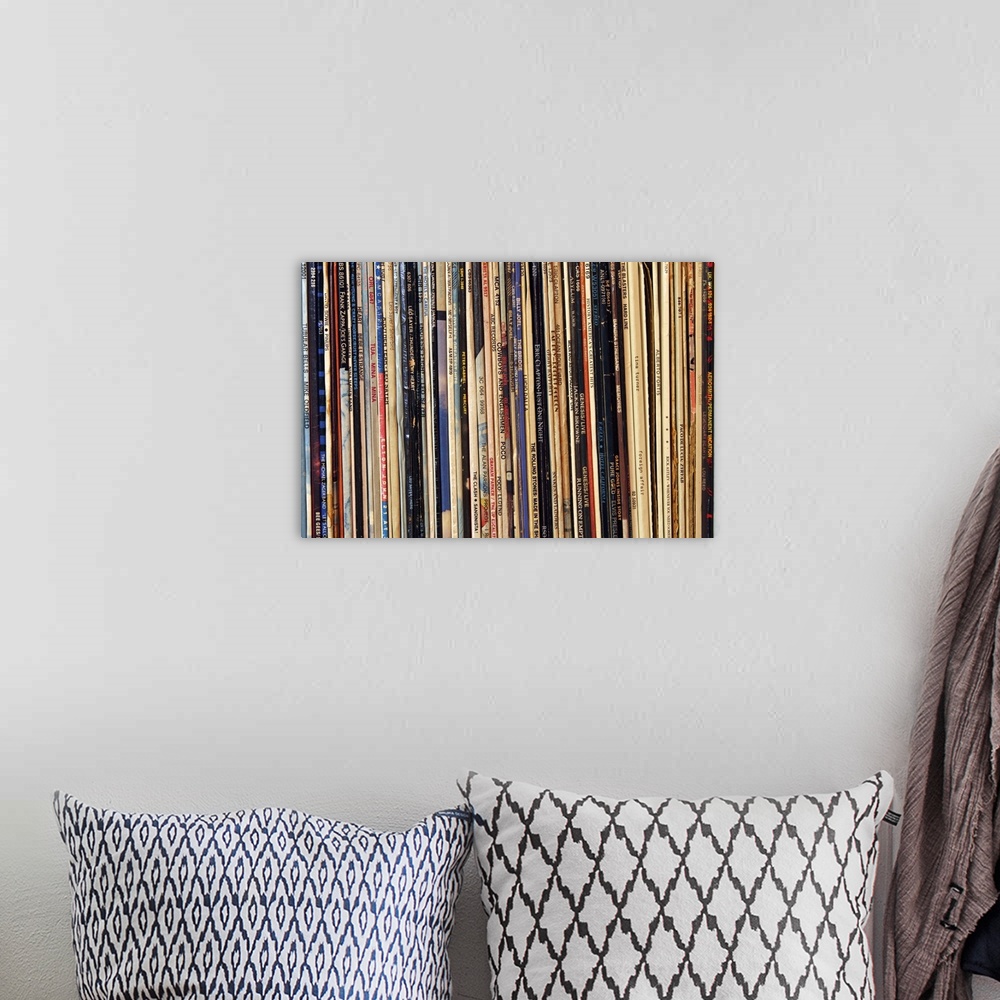 A bohemian room featuring Horizontal, close up photograph of a row of tightly packed records in their sleeves.