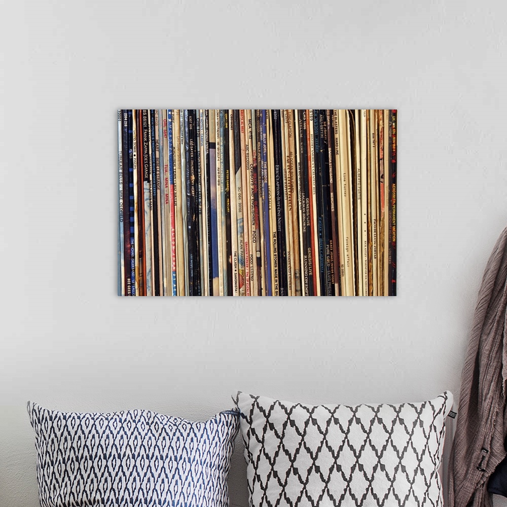 A bohemian room featuring Horizontal, close up photograph of a row of tightly packed records in their sleeves.