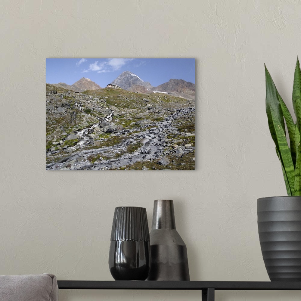 A modern room featuring Pizzini hut (2706 m) in the upper Sondrio province, Italy. In the background, the tallest peak is...