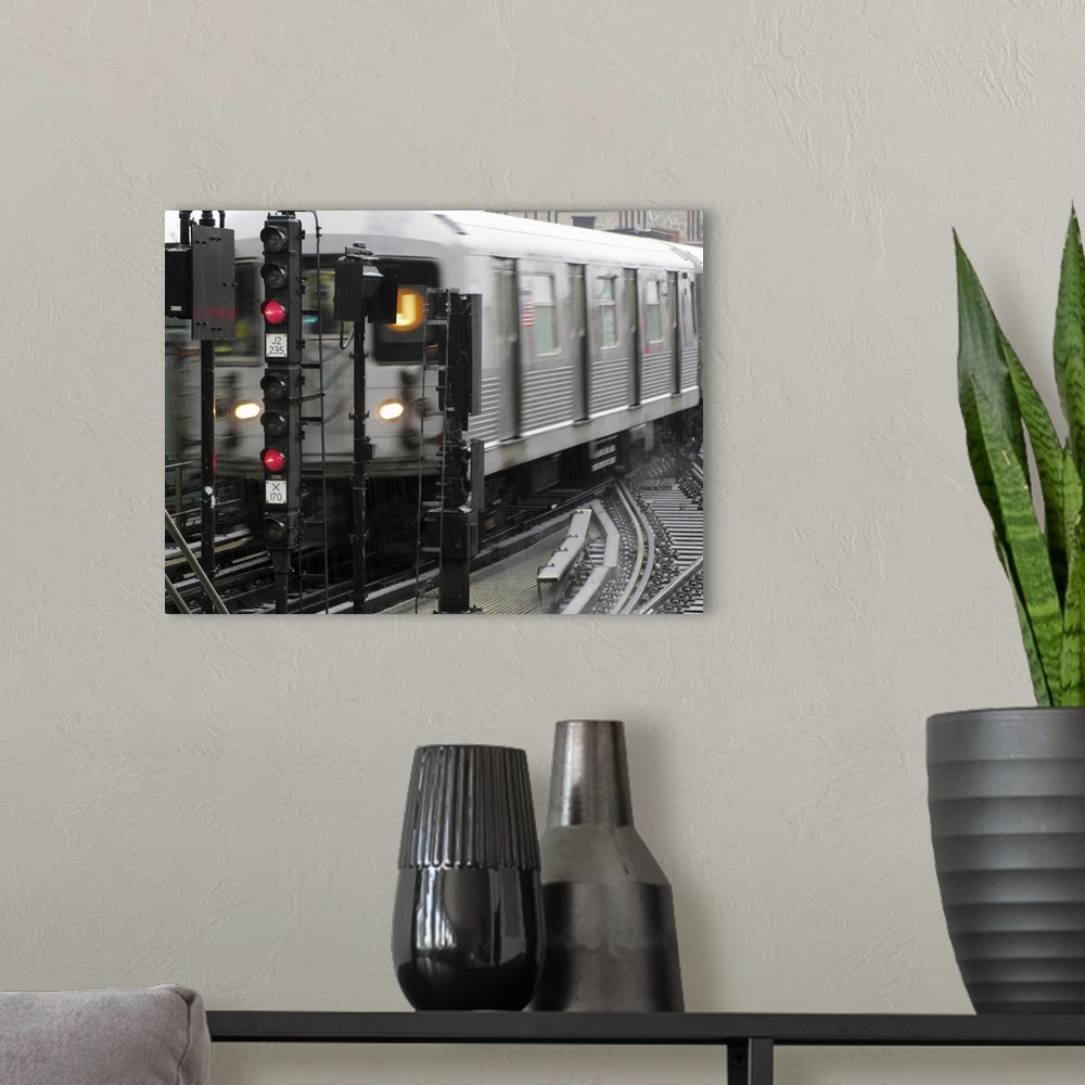 A modern room featuring Photograph taken of a subway train while it is in motion.