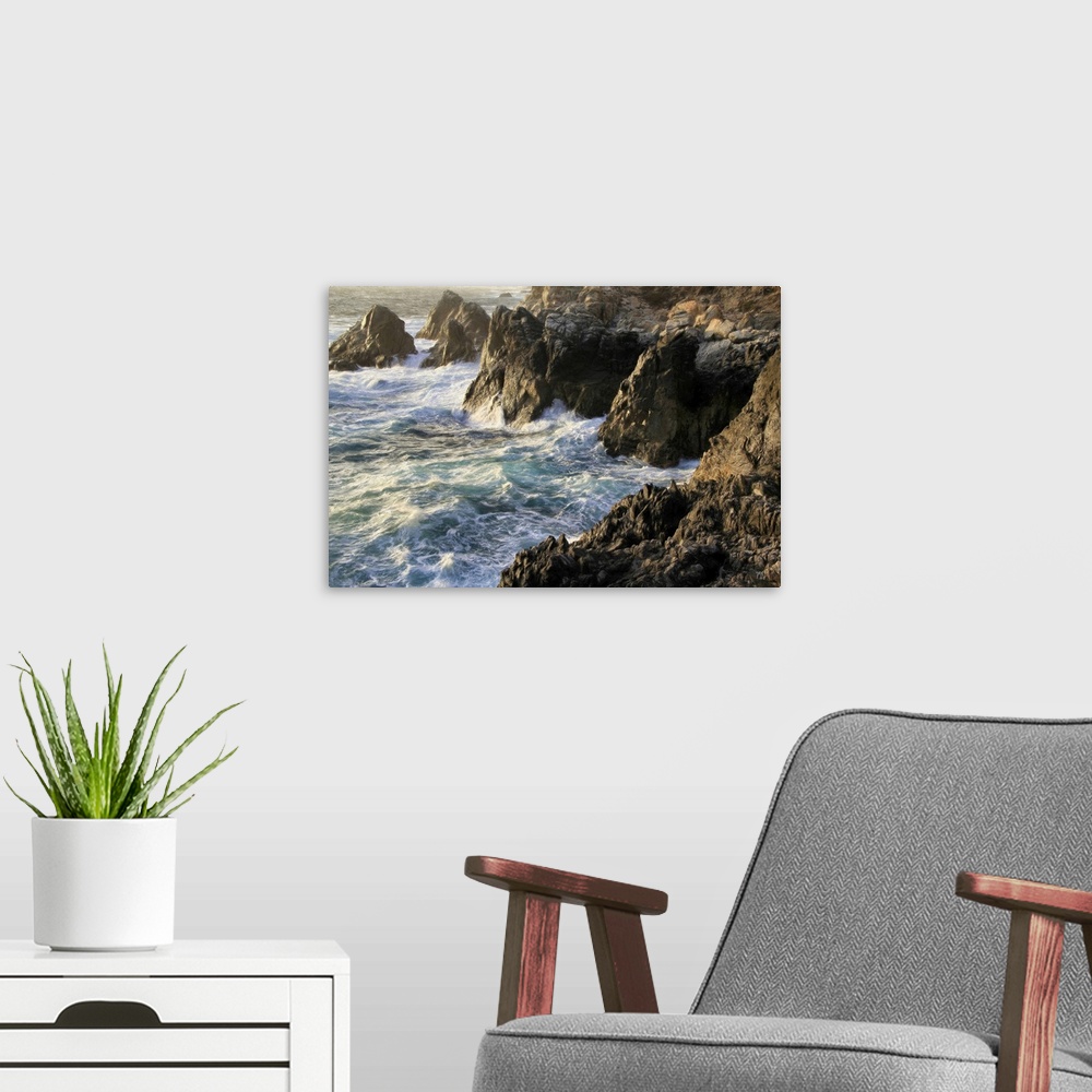 A modern room featuring Lying chest down on a rocky cliff about 40 feet above crashing waves, Michael Lynberg captured th...