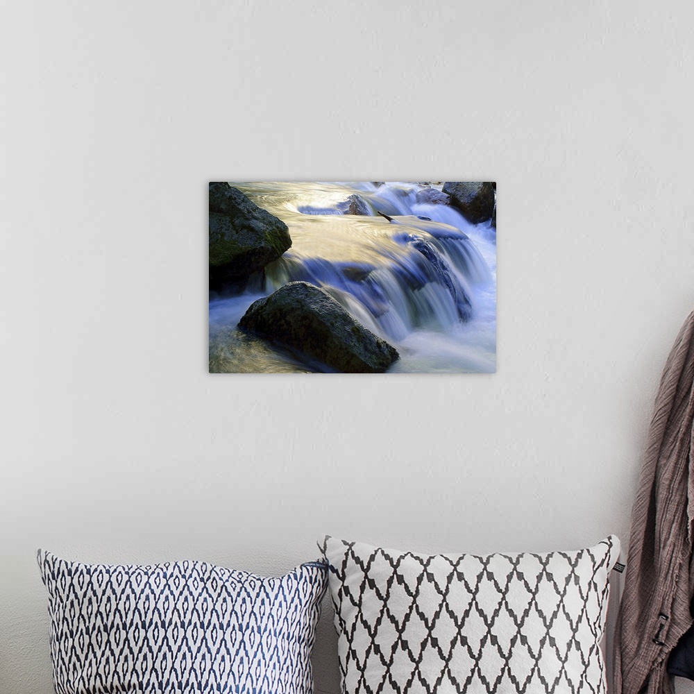 A bohemian room featuring Long exposure shot of water in a stream rushing over a rocky riverbed, creating a small waterfall.