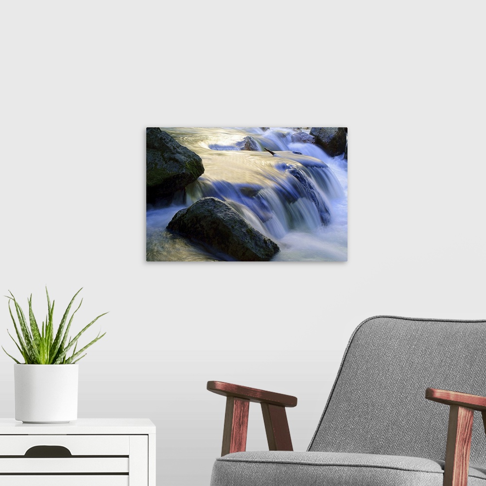 A modern room featuring Long exposure shot of water in a stream rushing over a rocky riverbed, creating a small waterfall.