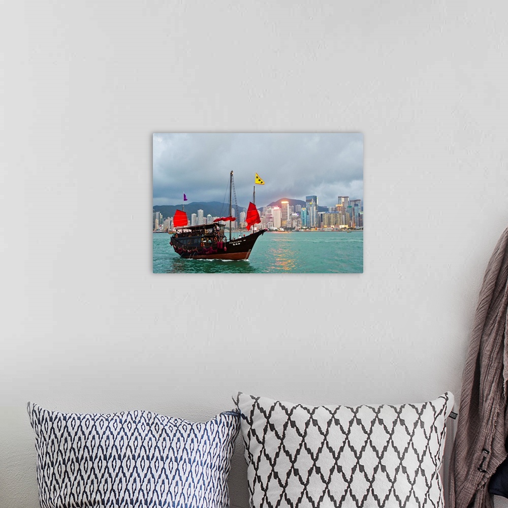 A bohemian room featuring A boat named Aqualuna in Victoria Harbor with the Hong Kong skyline in the distance.