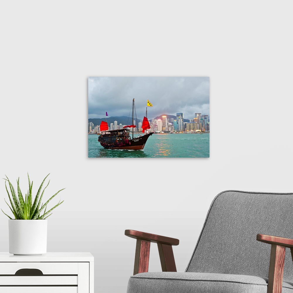 A modern room featuring A boat named Aqualuna in Victoria Harbor with the Hong Kong skyline in the distance.