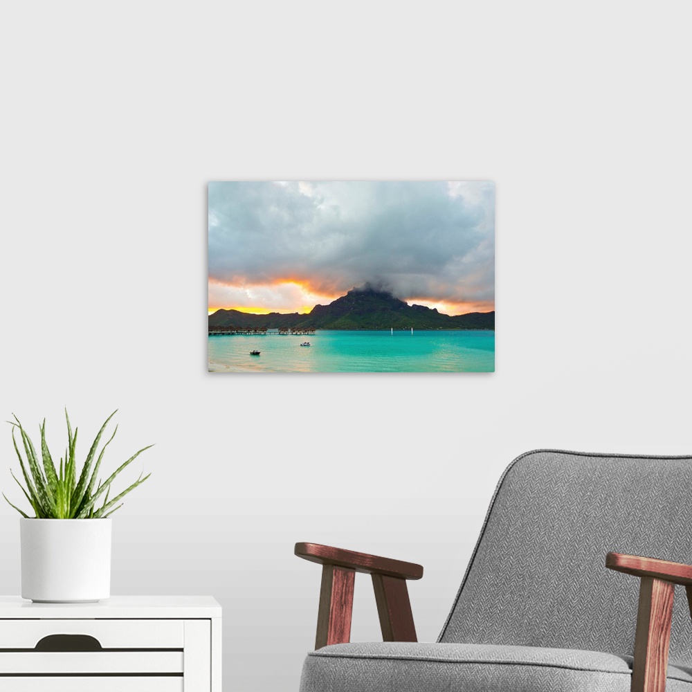 A modern room featuring A cloudy sunset over Mount Otemanu and the Pacific Ocean.