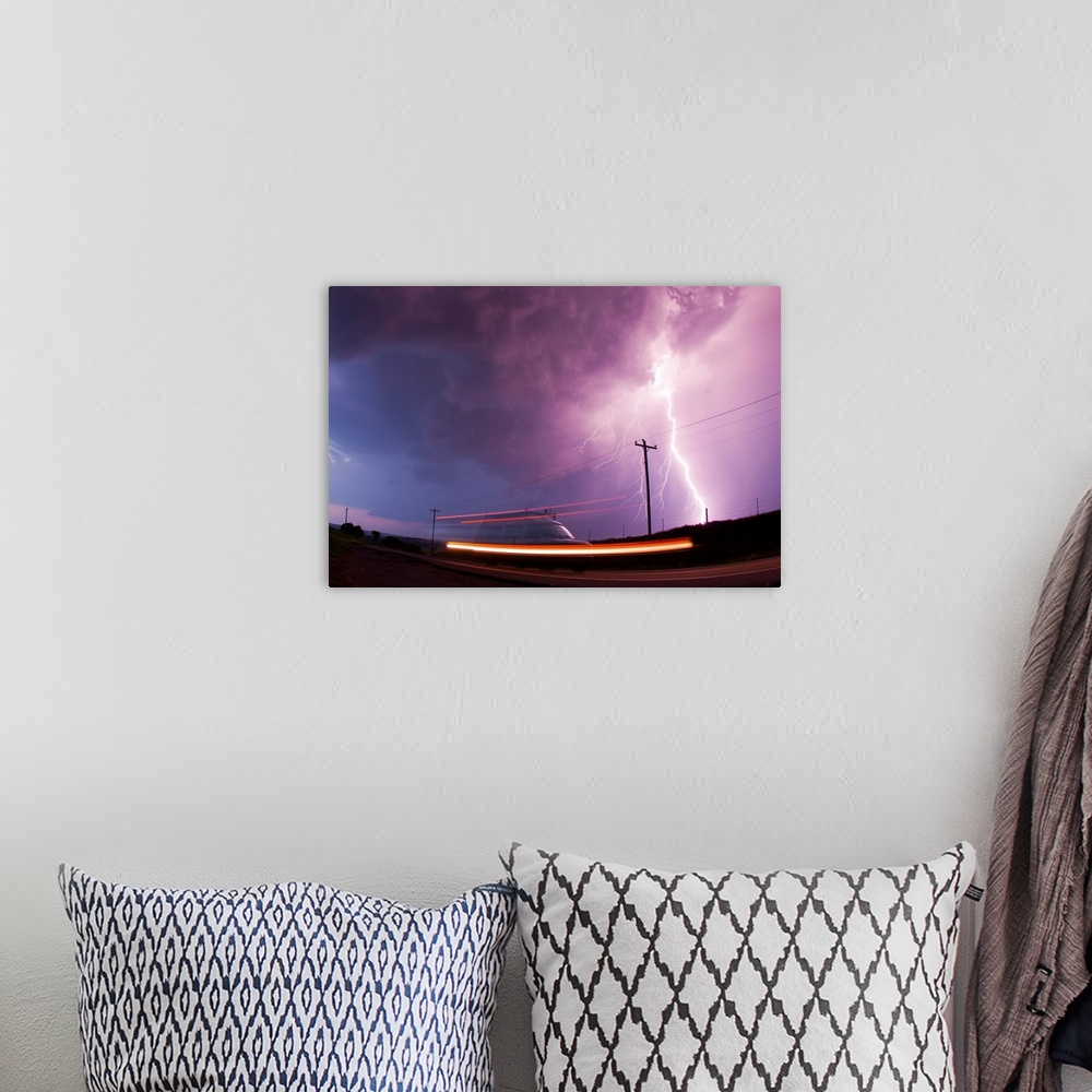 A bohemian room featuring A large lightning bolt strikes behind a storm chaser's moving van.