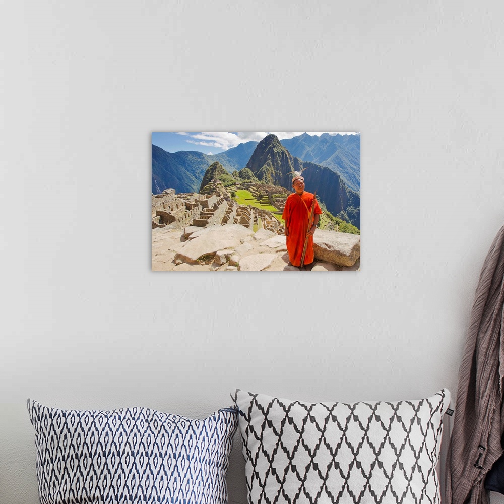 A bohemian room featuring A local tribesman with a spear chants on a cliff at Machu Picchu.