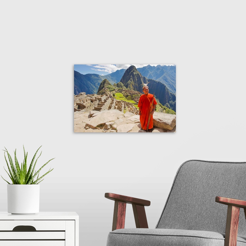 A modern room featuring A local tribesman with a spear chants on a cliff at Machu Picchu.