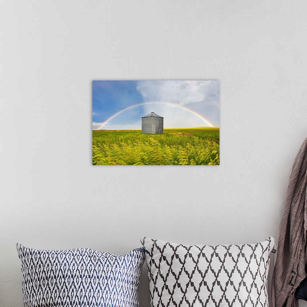 A bohemian room featuring A rainbow over a grain silo and wheat field after a thunderstorm.