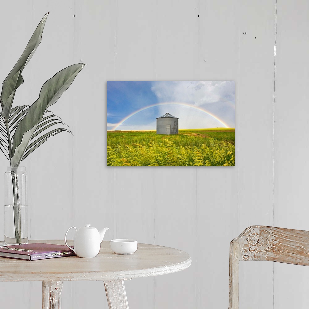 A farmhouse room featuring A rainbow over a grain silo and wheat field after a thunderstorm.