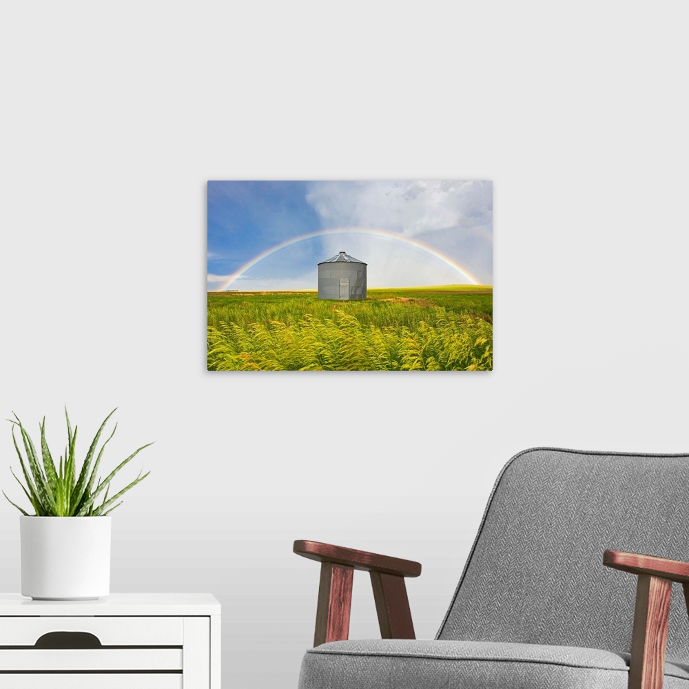 A modern room featuring A rainbow over a grain silo and wheat field after a thunderstorm.
