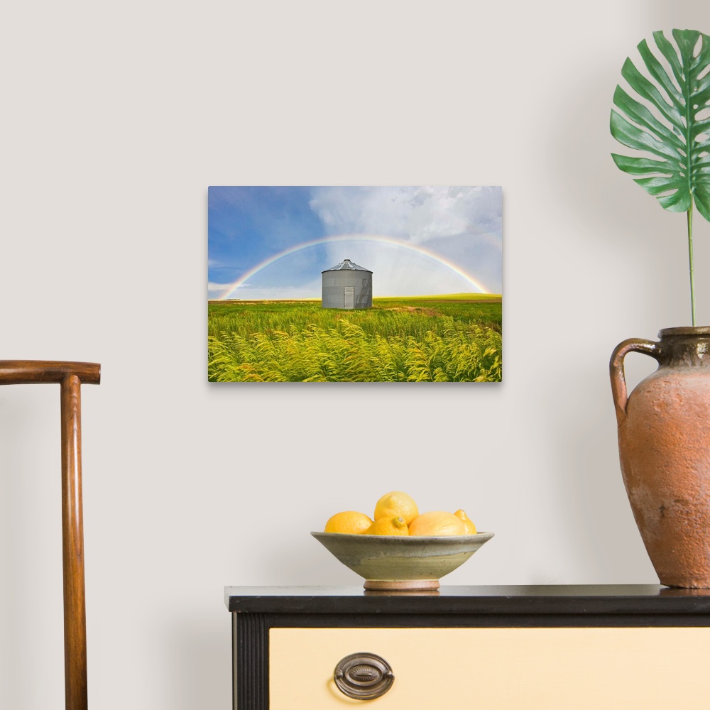 A traditional room featuring A rainbow over a grain silo and wheat field after a thunderstorm.