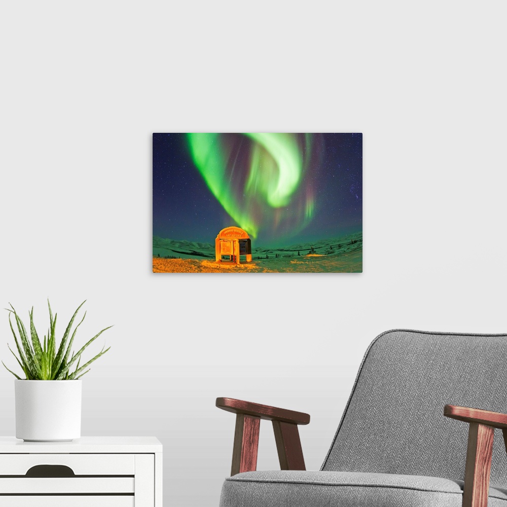 A modern room featuring An aurora borealis near the famous Arctic Circle sign.