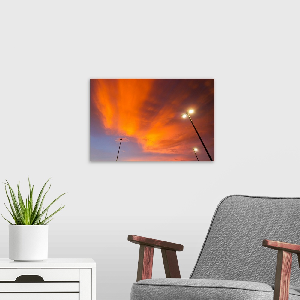 A modern room featuring Bright orange illuminated clouds during sunset.