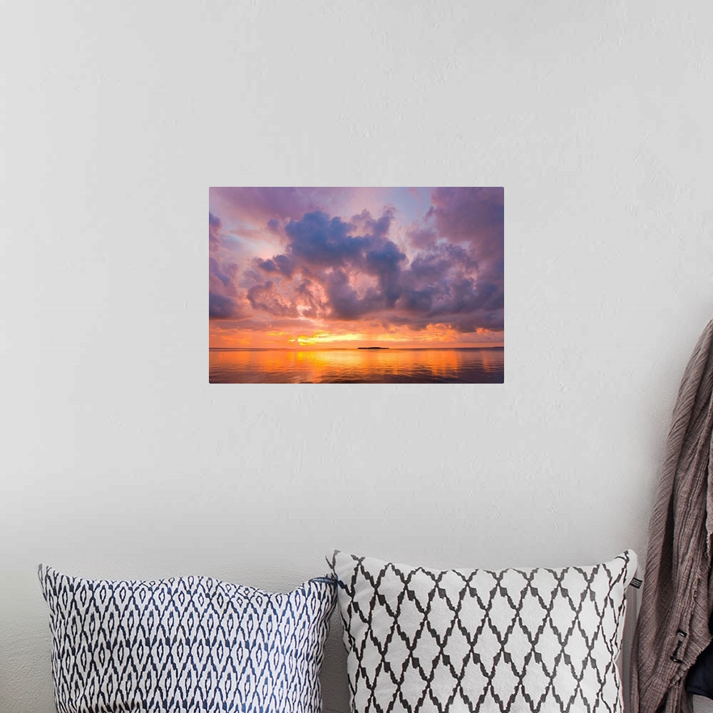 A bohemian room featuring Cumulus cloud set up and threaten to produce a waterspout at sunset.