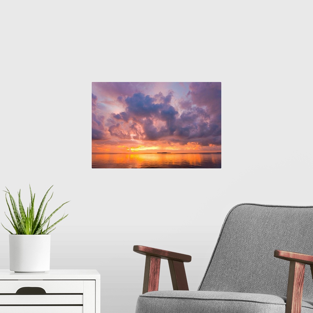 A modern room featuring Cumulus cloud set up and threaten to produce a waterspout at sunset.