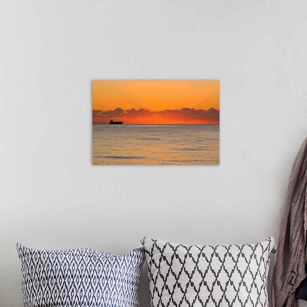 A bohemian room featuring A silhouetted ship moments before the sun rises over the horizon.