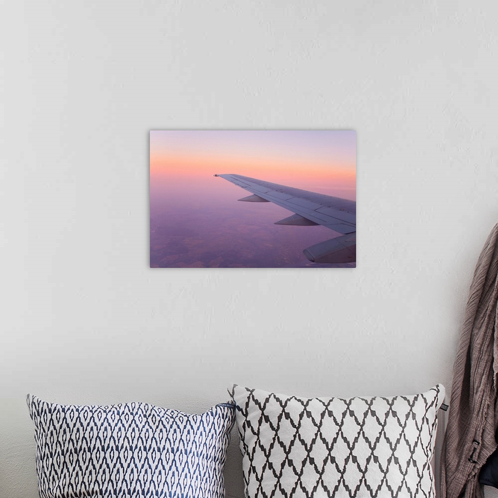 A bohemian room featuring Looking out and airplane window at sunset with a purple sky.