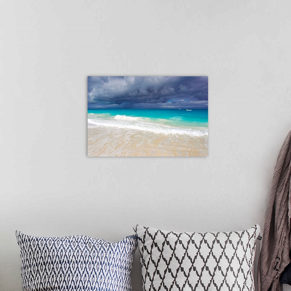 A bohemian room featuring Storm clouds roll in over turquoise waters and a beach.