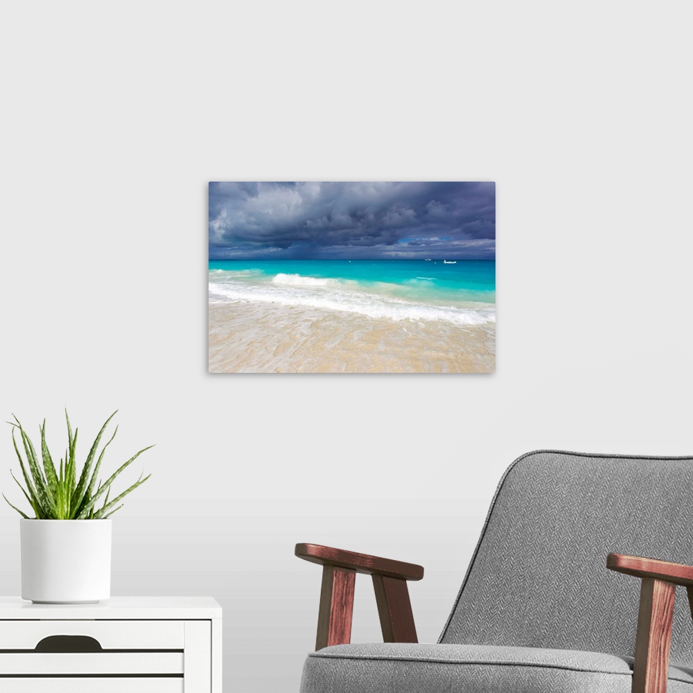 A modern room featuring Storm clouds roll in over turquoise waters and a beach.