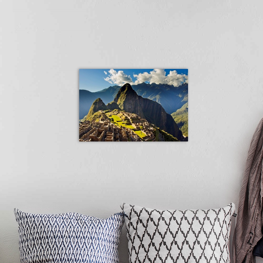 A bohemian room featuring Sun shining through the Andes mountains onto Machu Picchu at sunset.