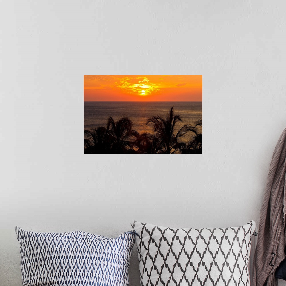 A bohemian room featuring Sunset over the Caribbean Sea and silhouetted palm trees.