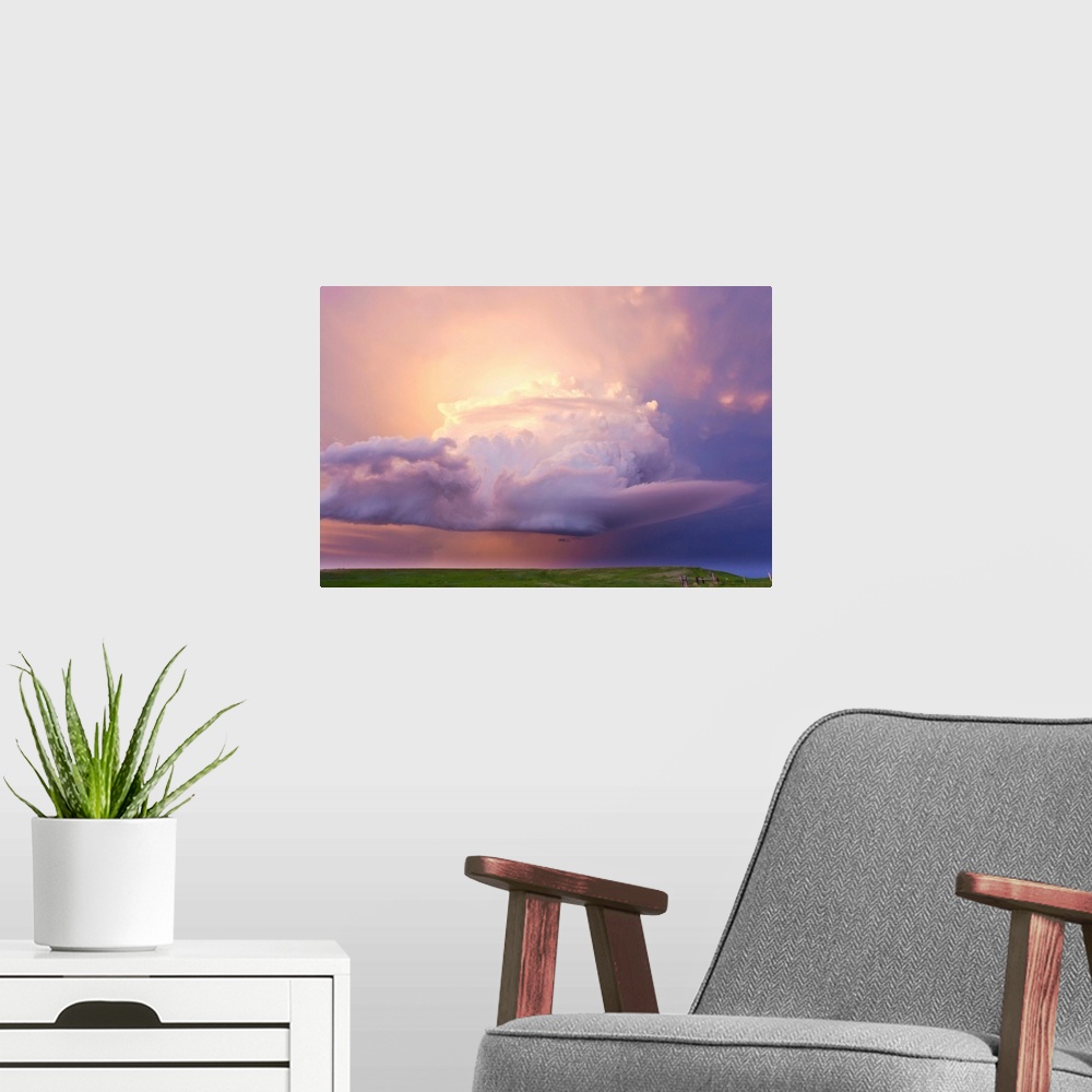 A modern room featuring Sunset paints a decaying thunderstorm and the sky a glowing purple and pink.