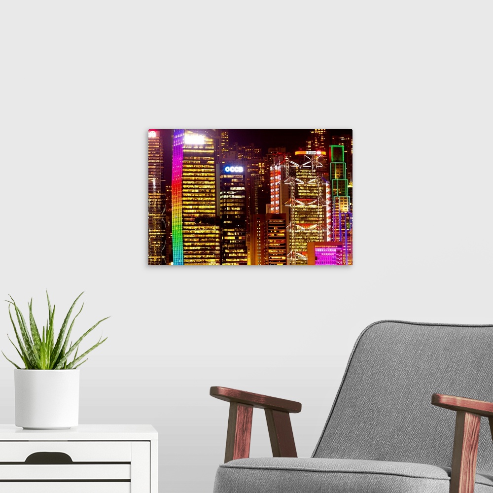 A modern room featuring The colorful Hong Kong skyline completely lit up at night.
