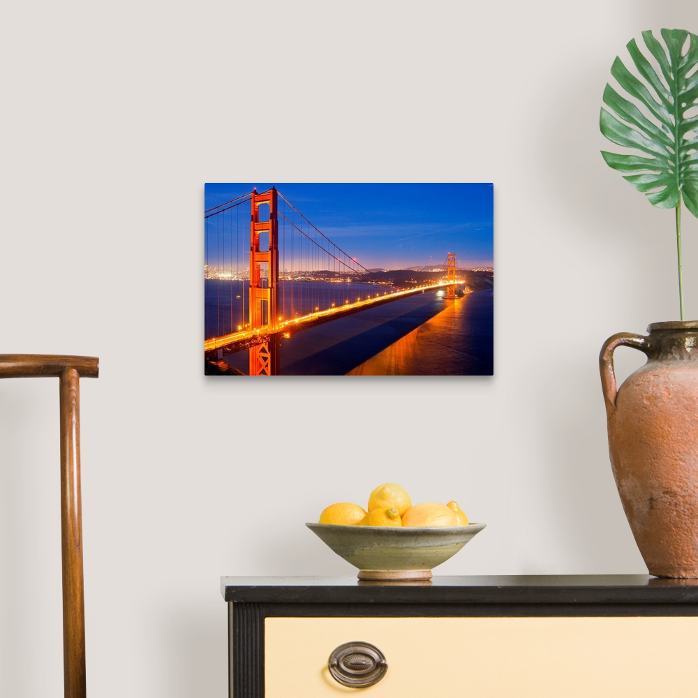 A traditional room featuring The Golden Gate Bridge illuminated at night.