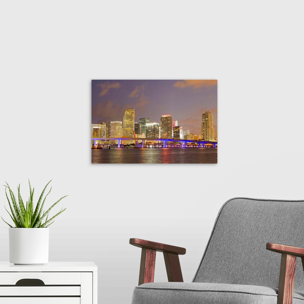 A modern room featuring The Miami causeway and skyline at night.
