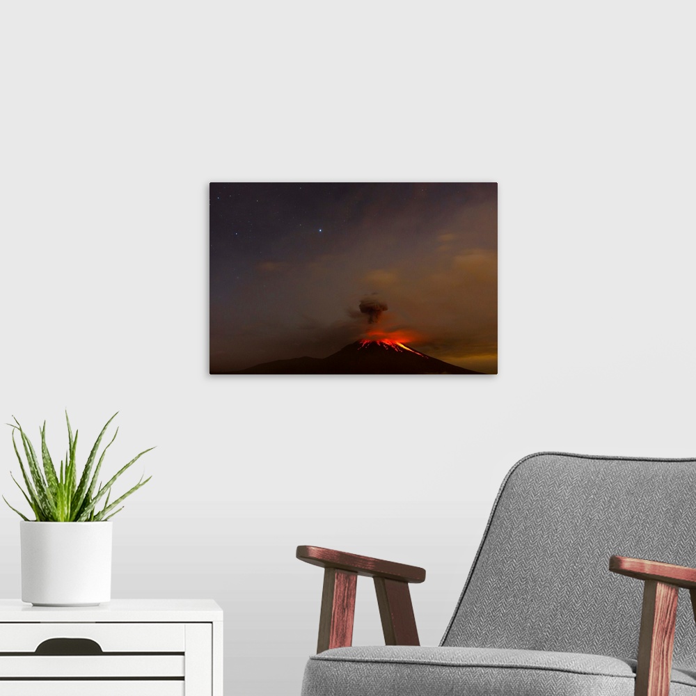 A modern room featuring The Tungurahua volcano erupting at night under a starry sky.