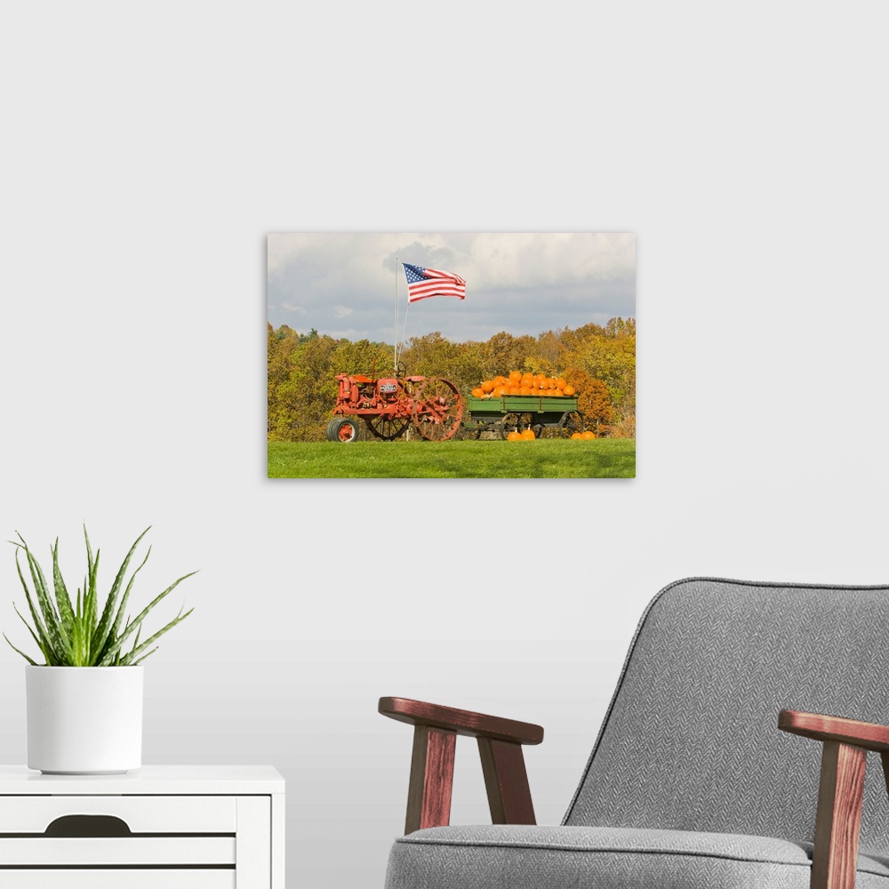 A modern room featuring The United States flag flying over tractor wagon filled with pumpkins.