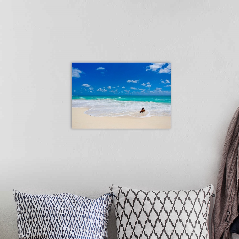 A bohemian room featuring Woman enjoys a perfect beach day of clear skies and blue waters.