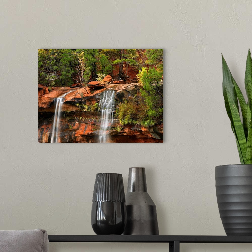A modern room featuring Big canvas print of two waterfalls trickling down a rocky cliff in Utah.