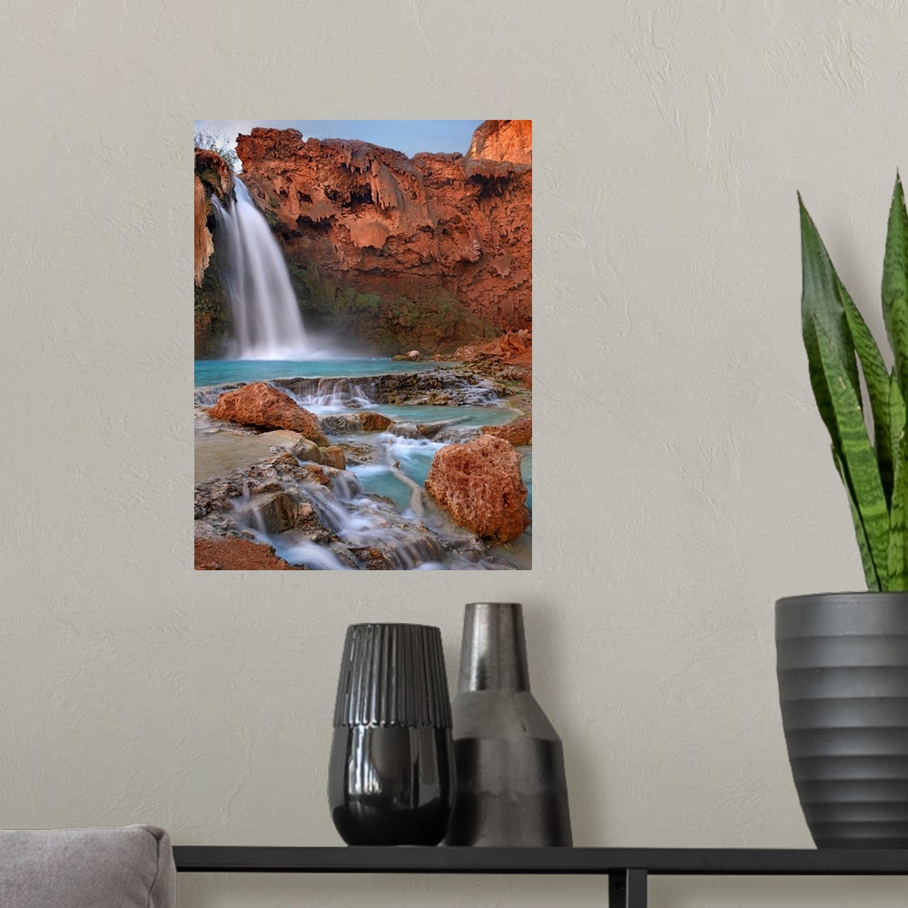 A modern room featuring Large photograph showcases water falling down a jagged cliff and splashing into the pool below be...