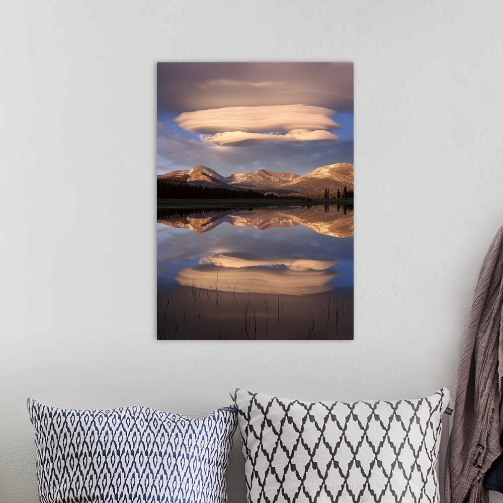 A bohemian room featuring Tall canvas photo art of billowing clouds above rolling hills reflected in the water.