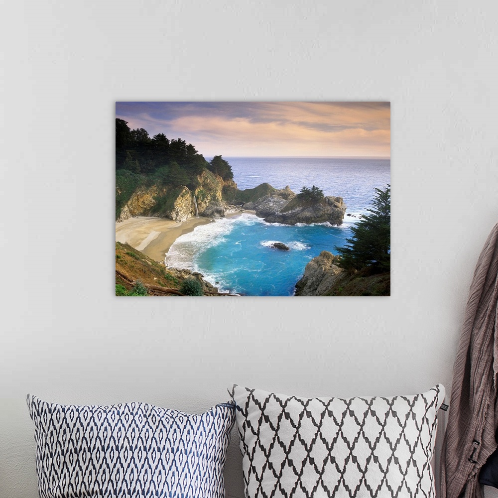 A bohemian room featuring This scenic photograph shows a rocky landscape surrounding a sandy beach and waves washing up on ...